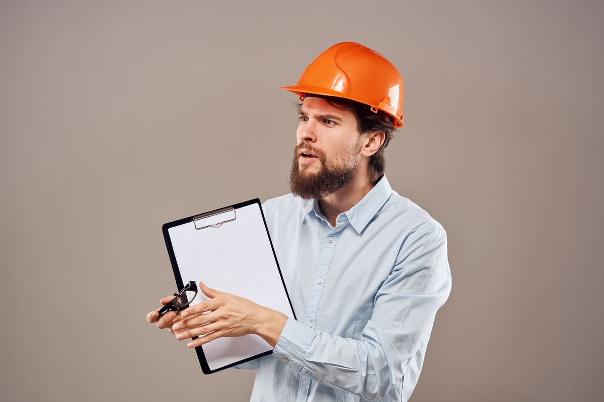 Construction worker in hard hat reviewing safety documentation on site